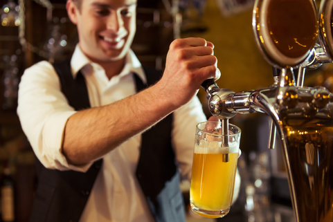 Scottish barman pulling a pint of beer in a pub late at night before last orders